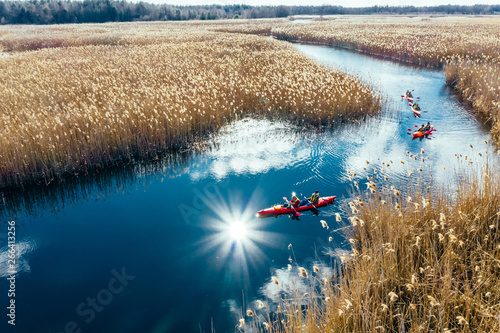 Εκτύπωση καμβά Group of people in kayaks among reeds on the autumn river.