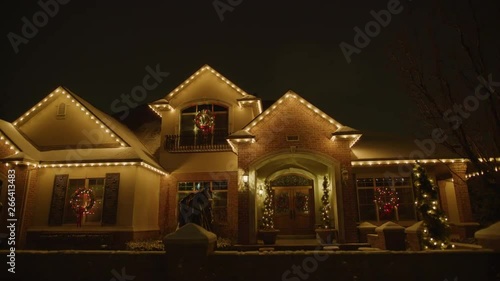 Panning shot of festive house with Christmas decorations illuminated at night / Cedar Hills, Utah, United States
