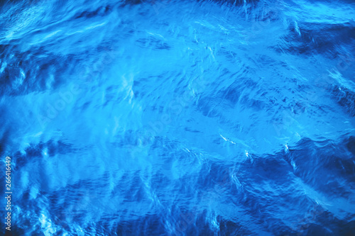 Fototapeta Naklejka Na Ścianę i Meble -  Closeup of calm sea water surface with water splashes in blue color. Ideal river, sea and ocean texture. Trendy fresh abstract nature background.