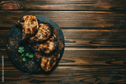 Pork bone steak on a wooden background with honey. Board slate. kenza, pepper photo