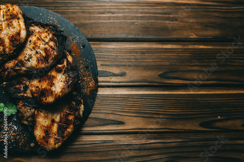 Pork bone steak on a wooden background with honey. Board slate. kenza, pepper photo