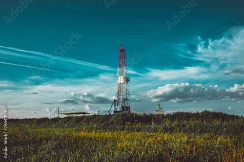Land oil drilling rig in a green field