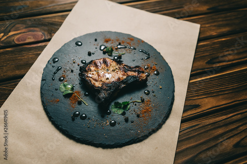 Pork bone steak on a wooden background with honey. Board slate. kenza, pepper photo