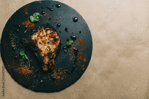 Pork bone steak on a wooden background with honey. Board slate. kenza, pepper photo