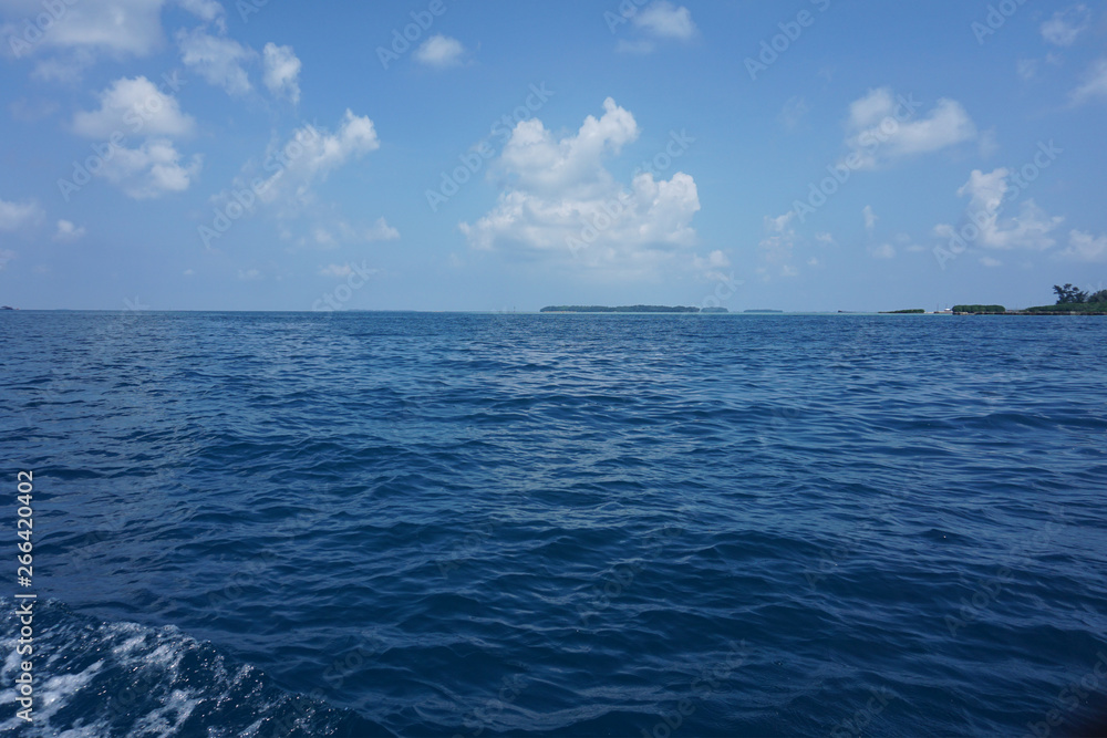 Beautiful expanse of turquoise tropical sea and white puffy clouds complete picture of tropical paradise