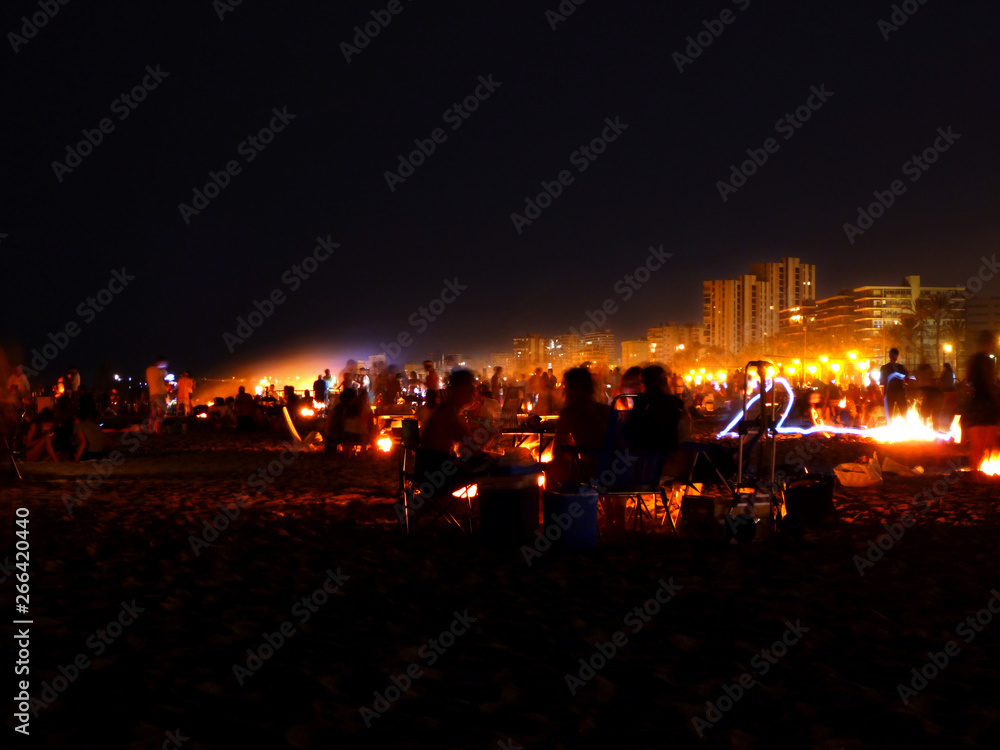 crowd celebrating a party on the beach at night