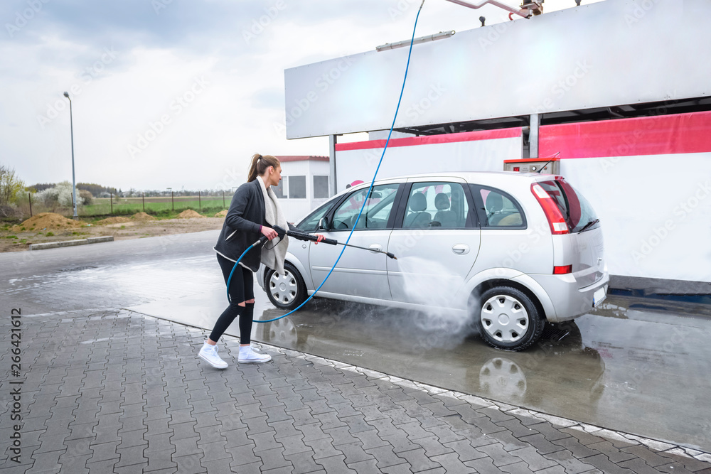 young woman washing herself a car