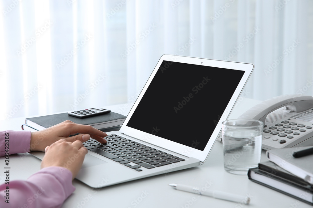 Young woman using modern laptop at table, closeup