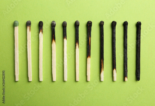 Row of burnt matches and whole one on color background  flat lay. Human life phases concept