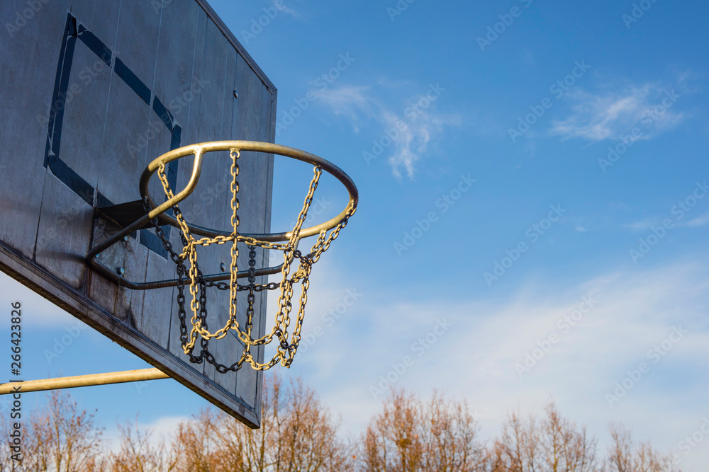 Detail of golden basketball basket outdoors in sunset blue sky
