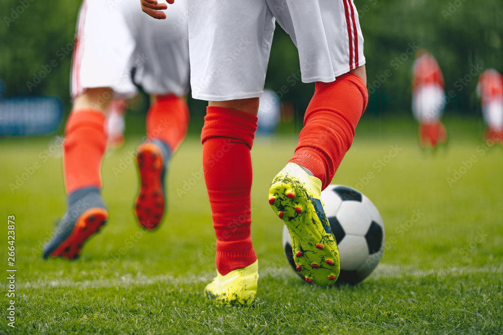Football/Soccer Running with the Ball. Soccer Player Training on the Field. Close-up View of Soccer Ball and Player Leg Football/Soccer Running with the Ball. Soccer Player Training on the Field. Close-up View of Soccer Ball and Player Leg
