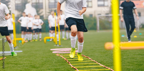 Boy Soccer Player In Training. Young Soccer Players at Practice Session. Boys Running Youth Agility Ladder Drills. Soccer Ladder Exercises
