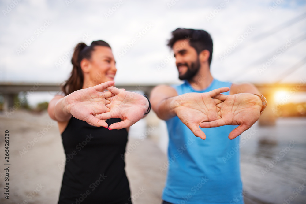 Active fitness couple stretching hands Active fitness couple stretching hands