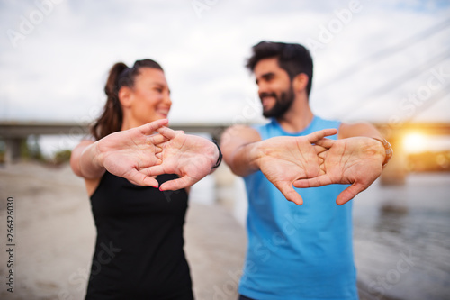 Active fitness couple stretching hands