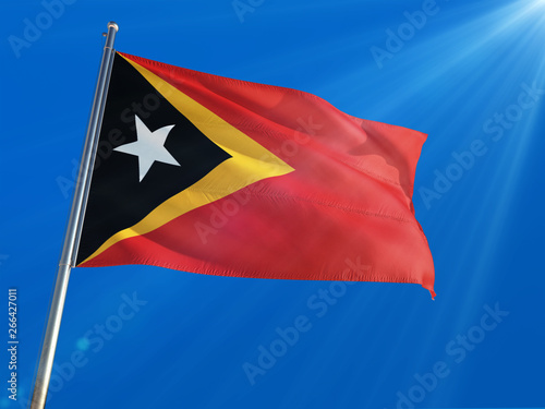 East Timor National Flag Waving on pole against deep blue sky background. High Definition