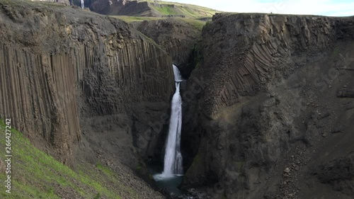 Magnificent Litlanesfoss waterfall, also called Studlabergsfoss, surrounded by long basalt columns, along the way to famous Hengifoss, Iceland. photo