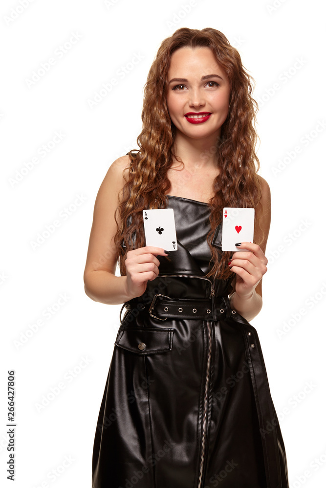 Pretty young redhead or brown-haired woman holding pair of aces in black leather dress isolated on white Pretty young redhead or brown-haired woman holding pair of aces in black leather dress isolated on white