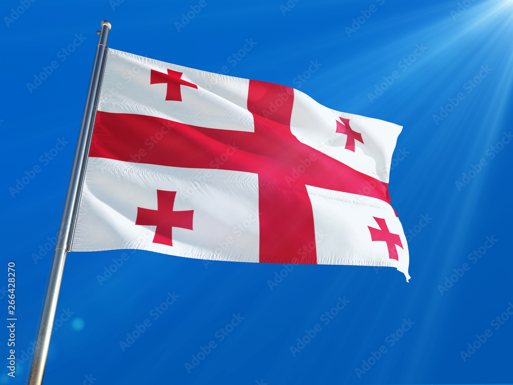 Georgia National Flag Waving on pole against deep blue sky background. High Definition