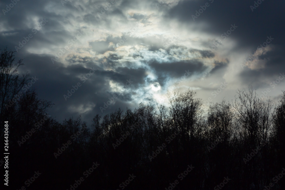 Fototapeta premium dark sun among the clouds