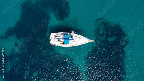 Aerial top view photo of fit man practising wind surfing in exotic open ocean bay with crystal clear emerald sea © aerial-drone