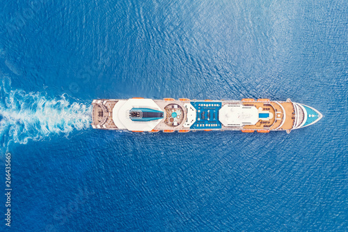 Cruise liner ship in ocean with blue water. Aerial top view