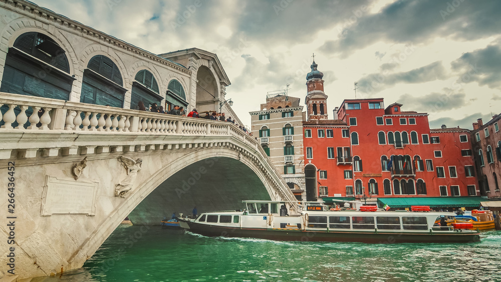 Vaporetto passes underneath Rialto Bridge. The bridge is oldest bridge crossing the Grand Canal  in Venice, Italy