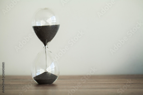 Time passing. A side view of an hourglass with falling sand