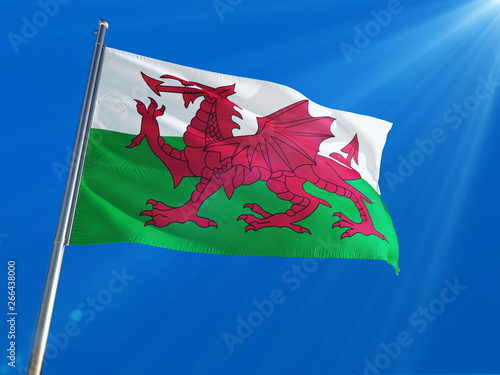 Wales - Galler National Flag Waving on pole against deep blue sky background. High Definition