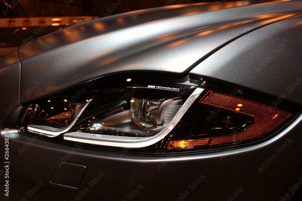 Close up view of silver gray luxury sports car headlight.