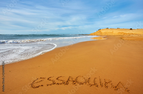 City name Essaouira written in the sand on the ocean coast