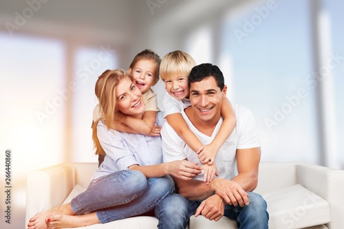 Beautiful smiling family sitting at sofa at home