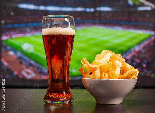 Konstfotografi Beer glasses and chips in front of tv, football at home