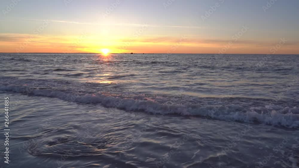 A morning sunrise at the beach on a clam morning with a golden sky. A morning sunrise at the beach on a clam morning with a golden sky.
