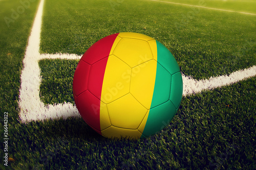 Guinea ball on corner kick position  soccer field background. National football theme on green grass.