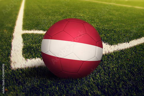 Latvia ball on corner kick position  soccer field background. National football theme on green grass.