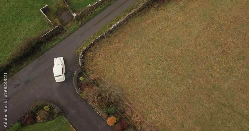 Classic Wedding car procession leaves church in Galway, Ireland. Aerial top down view