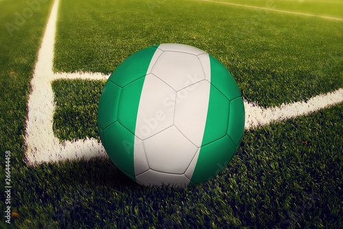 Nigeria ball on corner kick position  soccer field background. National football theme on green grass.