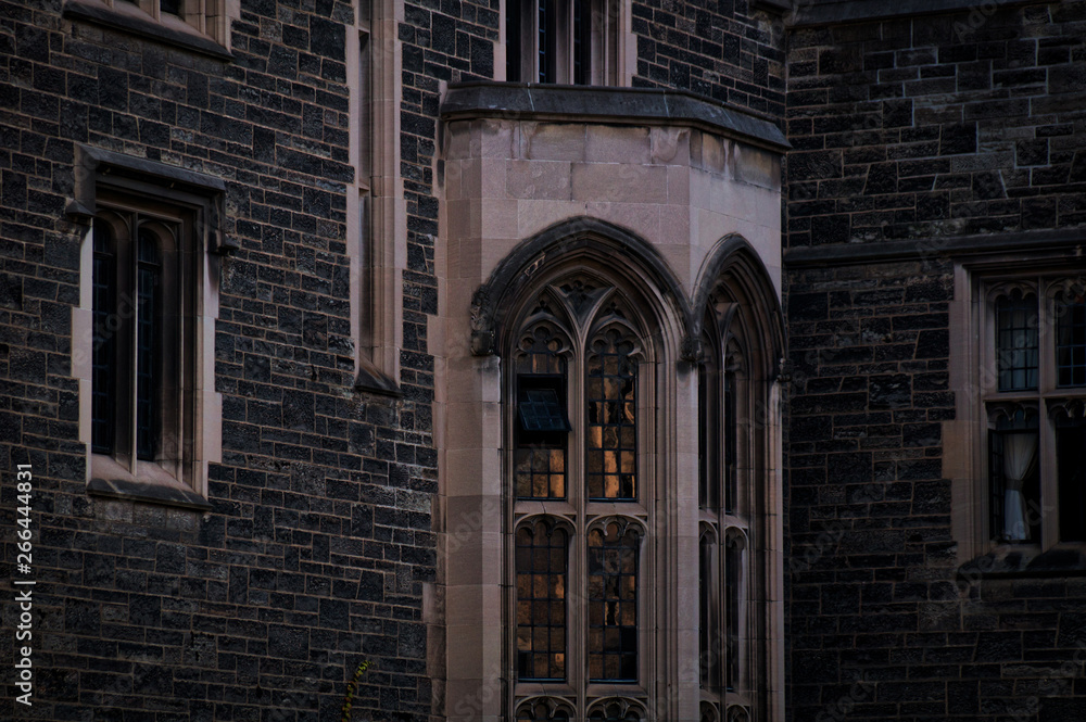 Obraz premium Toronto, Canada - 20 10 2018: Part of the exterior of the historic Hart House building in the University of Toronto with stone walls and bay window in the evening dusk