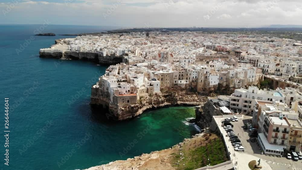 Aerial rising pan over the wonderful coast of the romantic old town, Polignano a Mare (Puglia, Italy)