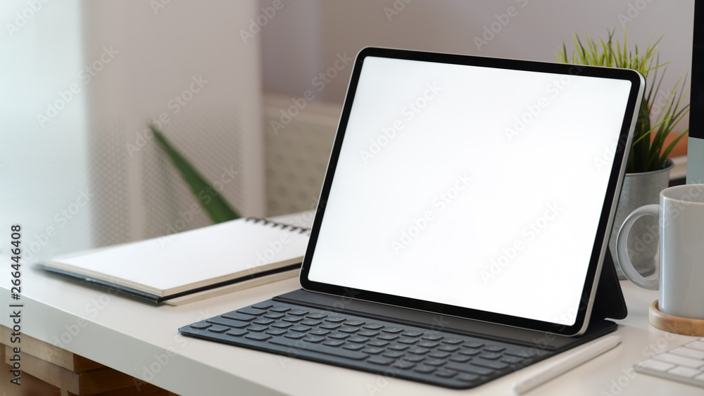 White screen tablet with smart keyboard on workspace desk White screen tablet with smart keyboard on workspace desk