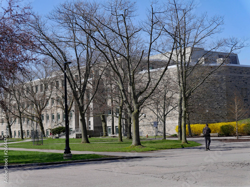 college campus with student walking in front of generic grey stone building