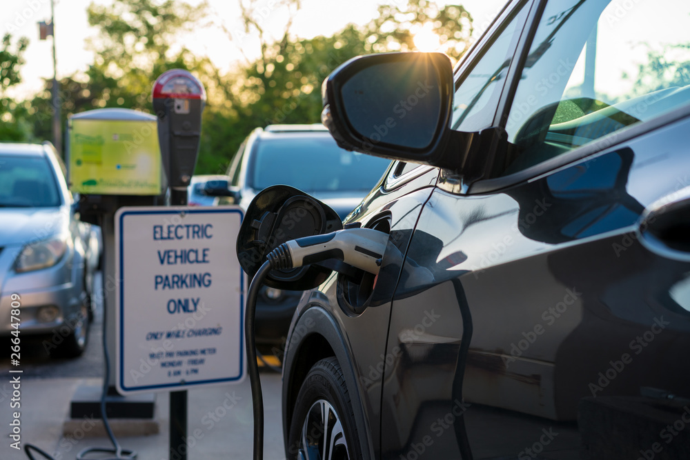 Parked electric vehicle charging plug, downtown Fayetteville Arkansas