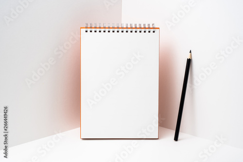 orange spiral notebook with white page on 3D space