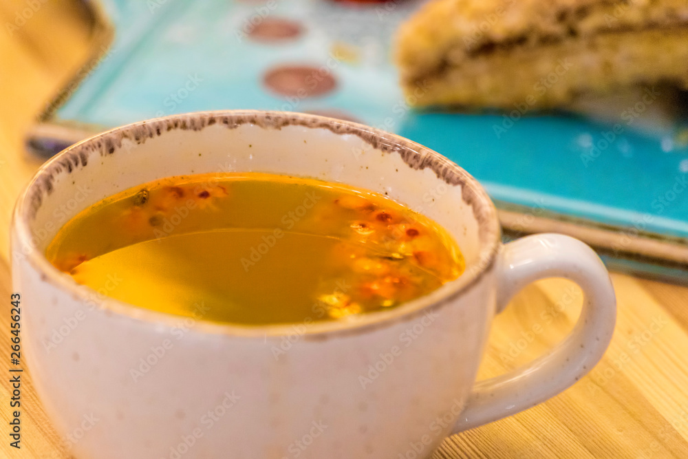 Sea buckthorn tea with millefeuille cake on wooden table Sea buckthorn tea with millefeuille cake on wooden table