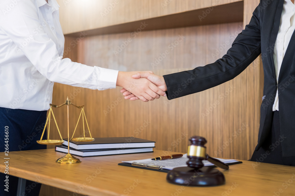 Φωτογραφία Gavel Justice hammer on wooden table with judge and client shaking hands after adviced in background at courtroom, lawyer service concept