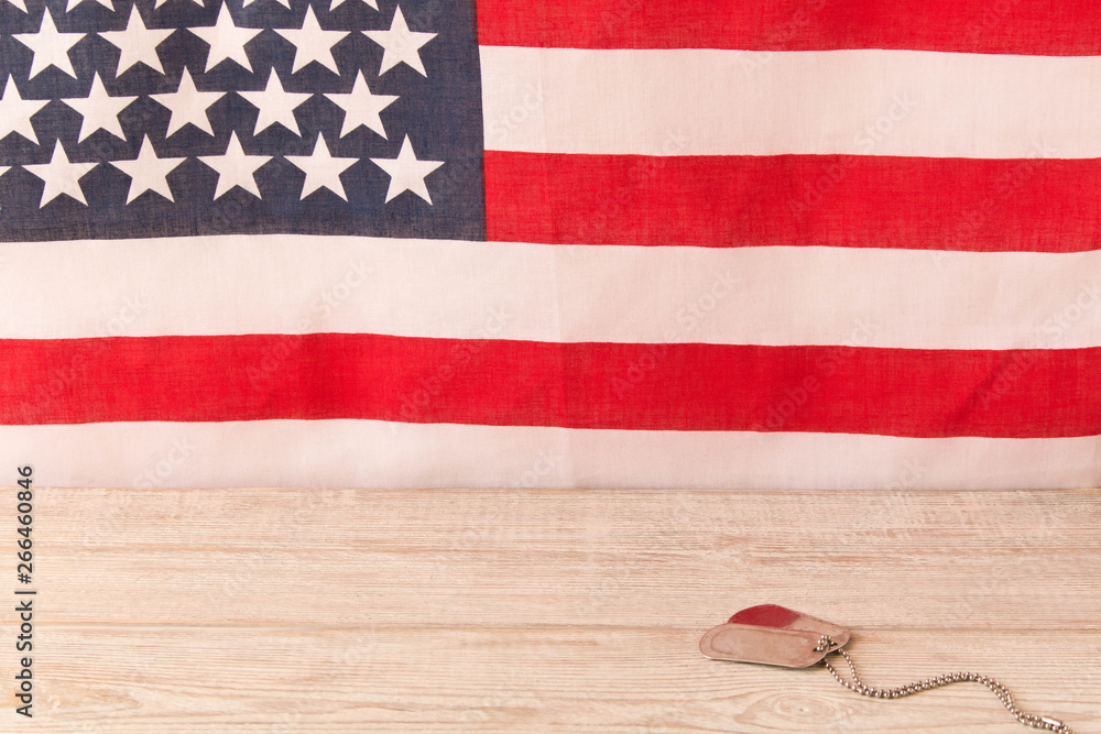 Obraz premium Army badges on a wooden table and an American flag in the background. Veterans Day.