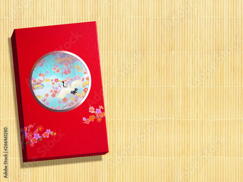 Red premium Chinese gift box for Chinese New Year, Anniversary, Mid-Autumn Festival, Valentine's Day, Birthday. On bamboo background.