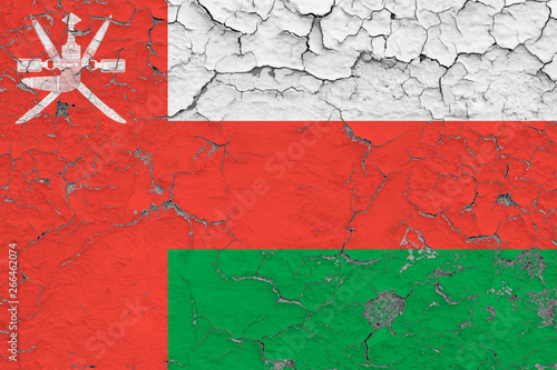 Flag of Oman painted on cracked dirty wall. National pattern on vintage style surface.