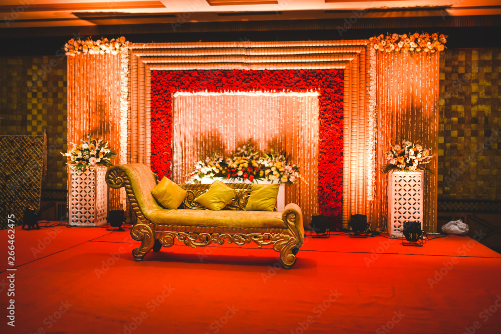 Huge stage at a wedding ceremony with beautiful yellow sofa for bride and  groom. floral background lit by multiple stage lights. foto de Stock |  Adobe Stock