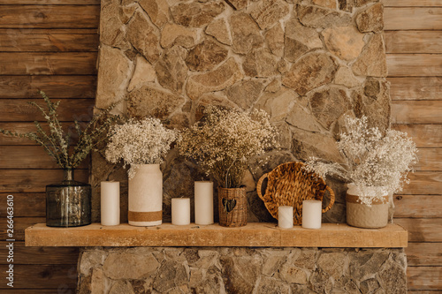 Fireplace Mantelpiece Decor Living Room Interior. Beautiful Country Brown Wooden Wall Copy Space. Rustic Vintage Stone Mantle with Candle and Flower